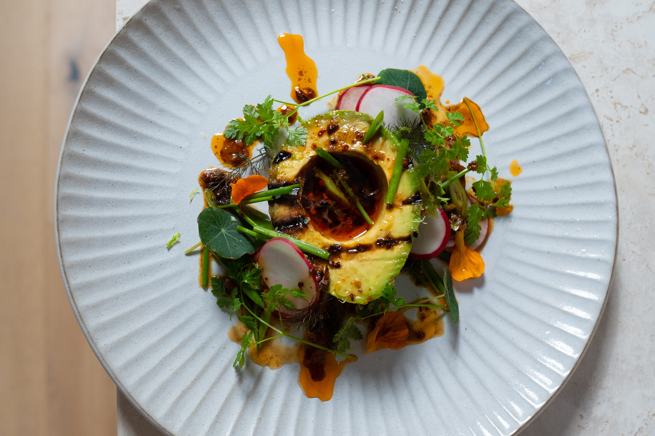 Grilled Australian Avocado, Radish Salad with Fermented Black Bean & Chilli Crisp Vinaigrette
